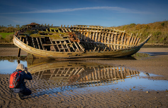 Photographer taking an imgae of a wrecked fishing boat