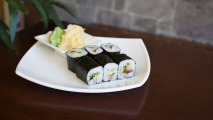 Vegan Maki sushi with rice and seaweed stuffed with vegetables and vegetarian ingredients.