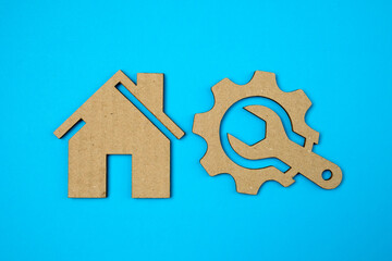 House and wrench in gear icon or logo on blue paper background. Business service concept. Gear service, technical problem service. repair equipment.