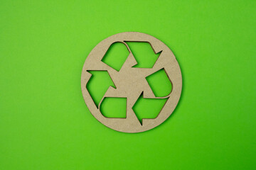 Kraft paper cut of reuse, reduce, recycle symbol on green paper background with copy space.
