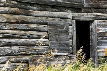 Close-up of a wall of an old wooden barn with door opening; Erickson, Manitoba, Canada