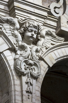 Decorative angel sculpture on a building with arches; Brussels, Belgium