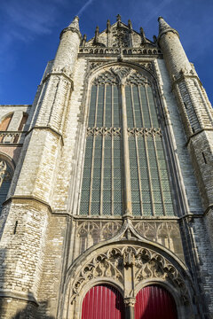 Looking up at Hooglandse Kerk church front with rounded steeples and blue sky; Leiden, Netherlands