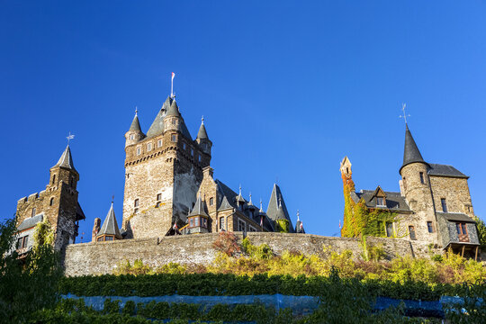 Looking up to old medieval stone castle with blue sky; Cochem, Germany