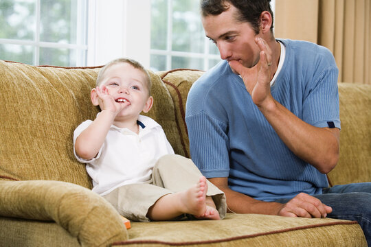 Father teaching son sign language - Powered by Adobe