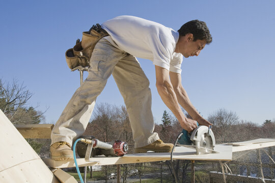 Carpenter cutting plank with a circular saw