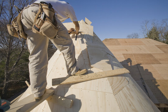 Carpenter working on the turret of a house