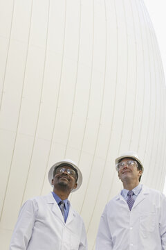 Two scientists standing in front of a digester tank