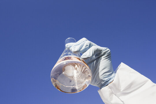 Scientist holding a flask of water sample