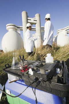 Water sample and PH meter with two scientists in the background