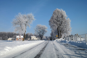Zimowy krajobraz na ulicy i ostrzeżenie przed ostrym zakrętem.