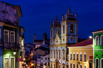 Night life in historic Pelourinho neighborhood, houses and churches during dusk in Salvador city in...