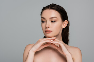 portrait of young and pretty woman with wet hair looking away isolated on grey