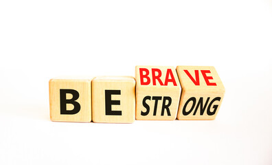 Be strong and brave symbol. Concept word Be strong Be brave on wooden cubes. Beautiful white table white background. Business be strong and brave concept. Copy space.