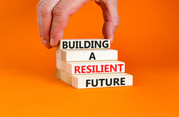 Building a resilient future symbol. Concept word Building a resilient future on wooden blocks. Beautiful orange table orange background. Business and building a resilient future concept. Copy space.
