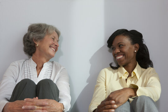 Two women sitting and smiling together