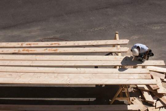 High angle view of a carpenter cutting bevels on rafters