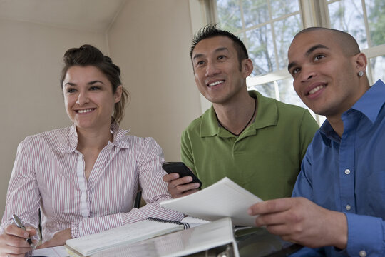 Young professionals working together at a table with documents and a smart phone