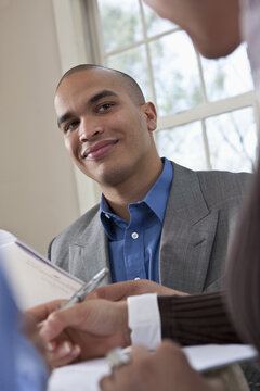 Young professionals working together at a table reviewing documents