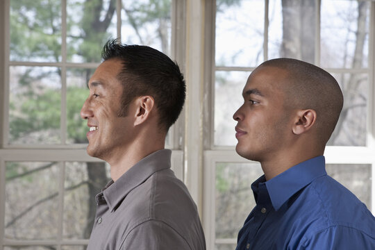 Portrait of the side view of two young businessmen standing facing left
