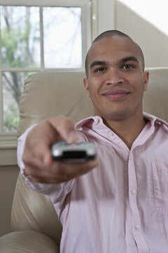 Young man with remote control pointed at the camera