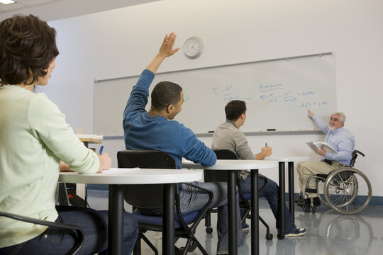 University professor with Muscular Dystrophy teaching his students in a classroom