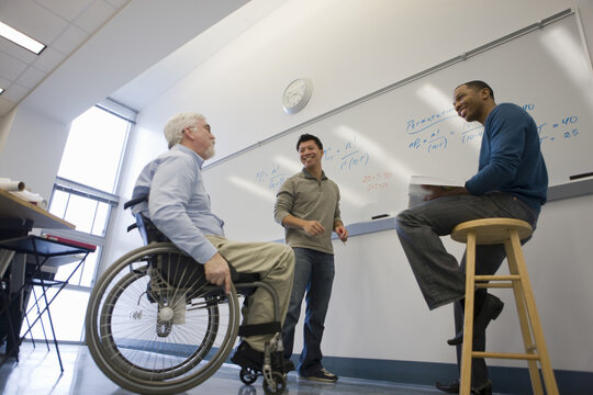 University professor with Muscular Dystrophy talking with his students in a classroom