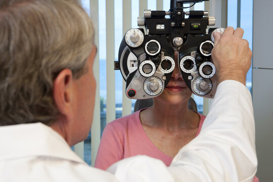 Ophthalmologist examining a woman's eyes with a phoropter