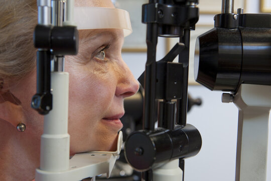 Woman getting eye exam with a slit lamp