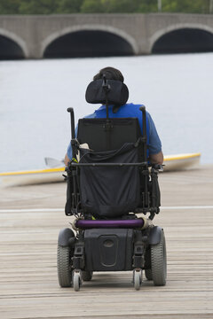 Man with cerebral palsy sitting in a motorized wheelchair on the dock