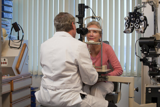 Ophthalmologist examining a woman's eyes with a slit lamp