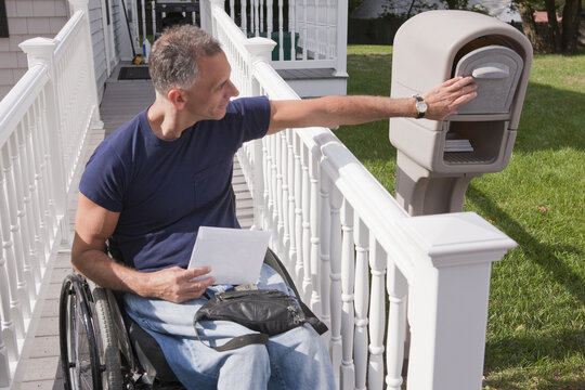 Man with spinal cord injury in a wheelchair getting his mails