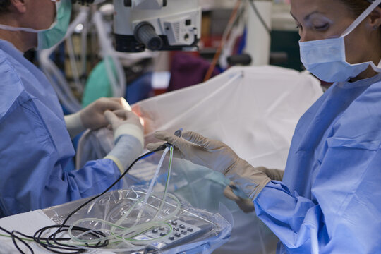 Surgical technologist passing a phaco hand piece to doctor during cataract surgery