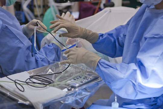 Surgical technologist passing a phaco hand piece to doctor during cataract surgery