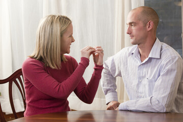 Woman signing word phrase 'Argument' in American Sign Language while communicating with a man