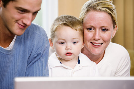 View of parents teaching their son to use a computer.