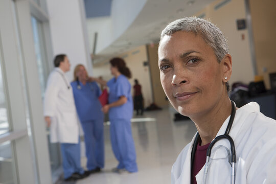 Portrait of a female doctor with her colleagues in the background