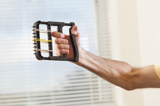 Man with Friedreich's Ataxia with deformed hands using hand strengthening equipment