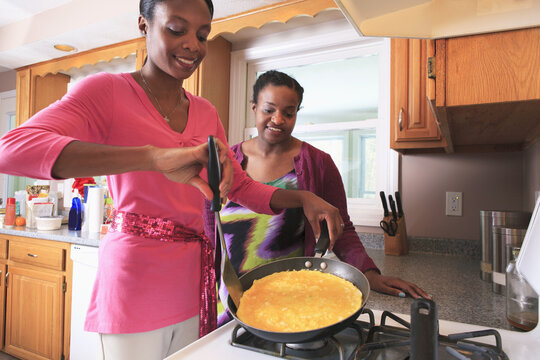 Two sisters cooking in the kitchen, one with learning disability