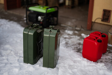 Сanisters with gasoline against portable mobile backup standby generator.