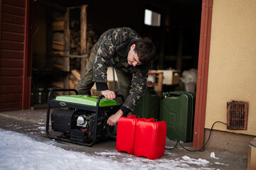 Man wear in military jacket with gasoline portable mobile backup standby generator.