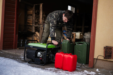 Man wear in military jacket with gasoline portable mobile backup standby generator.