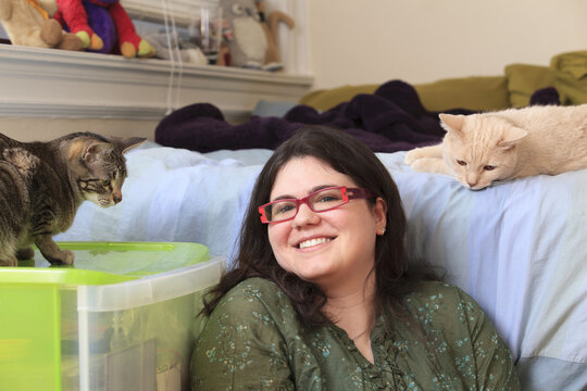 Woman with Asperger syndrome playing with her pet cats