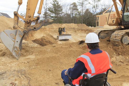 Construction engineer with spinal cord injury inspecting new foundation hole