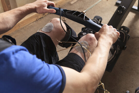 Man With Spinal Cord Injury Using His Rowing Machine With A Muscle Stimulator Attached