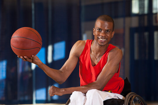 Man who had Spinal Meningitis in wheelchair holding basketball