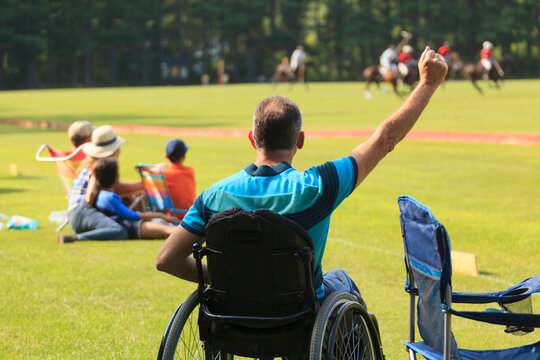 Man with spinal cord injury watching polo