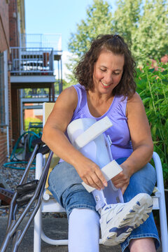 Woman with Spina Bifida adjusting leg brace so she can walk