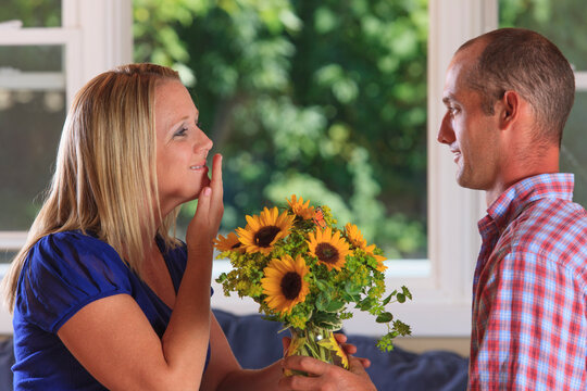 Husband giving flowers to his wife signing 'Thank You' in American sign language both with hearing impairments