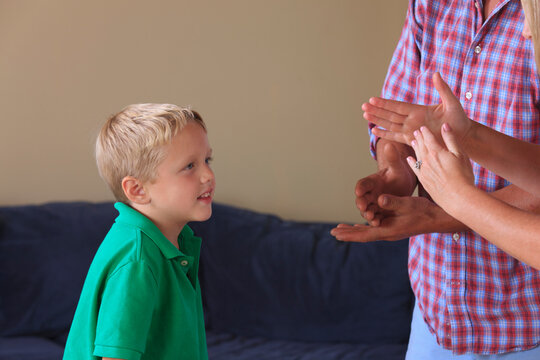Parents and son with hearing impairments signing 'stop, timeout' in American sign language